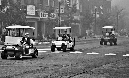 Golf carts driving down city street