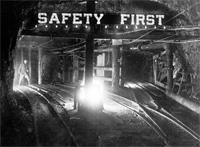 Safety First reflective sign over train tracks